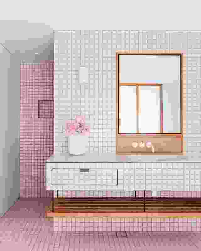 Square Italian tiles cover the floor, walls and vanity, enveloping the bathing space in textured, dusty pink.