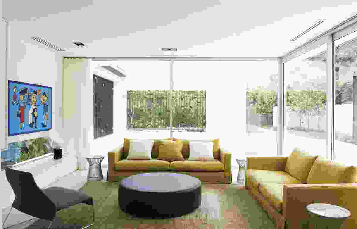 The living room looks out onto the outdoor pool “room” and beyond into the garden.