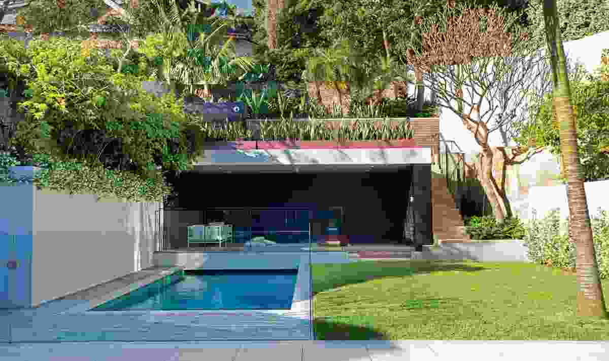 An enclosed courtyard with a pool connects the house to a lush garden at the rear.