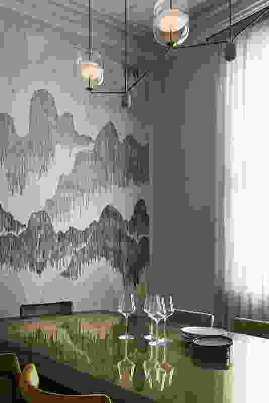 An elegant dining room is animated by textured wallpaper.