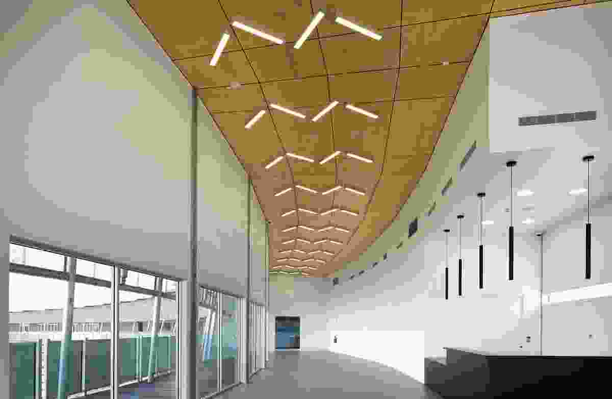 The interior of the arrival hall accentuates the slope of the roof, which steps down gradually from fourteen metres at the entry to 3.5 metres at the far end.