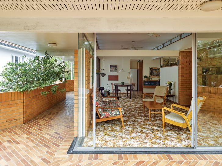 A freestanding brick wall and matching brick patio lend a sense of spatial enclosure to an otherwise open living room.
