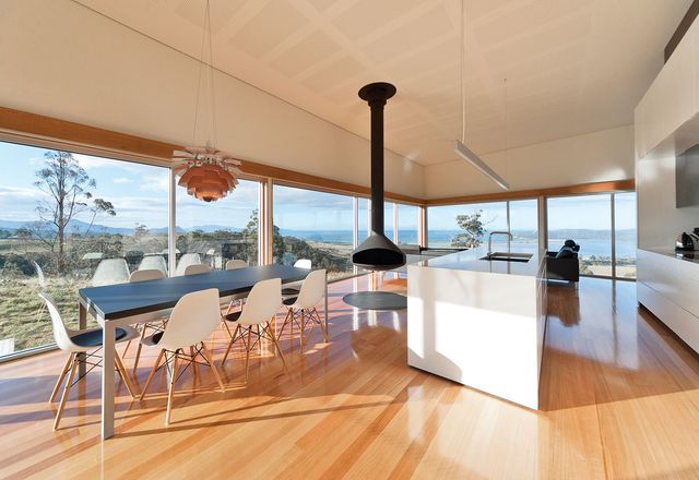 The kitchen and dining room are filled with light and focused towards views framed by glazing.