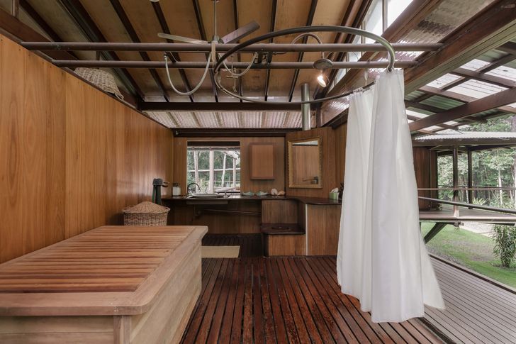 A rosewood bath and central shower celebrate the rituals of open-air bathing.