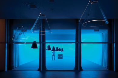 The space is serene and awash with a blue light, with cones hanging at different heights.