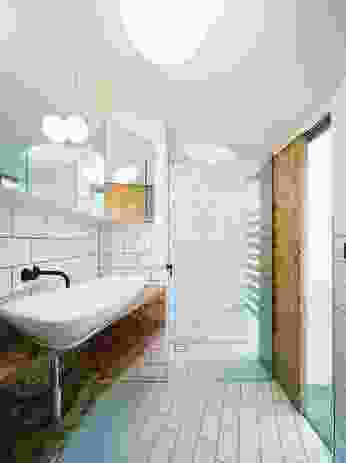 The bathroom has a lowered ceiling to be proportional to the dimensions of the room in plan. A playful circular cut-out above the shower is featured.