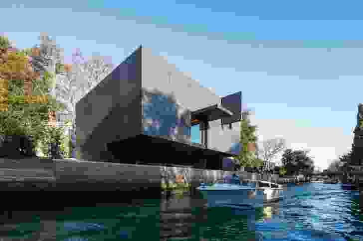 The brooding black box cantilevers over the canal, its recessed ground floor housing service areas and an office.