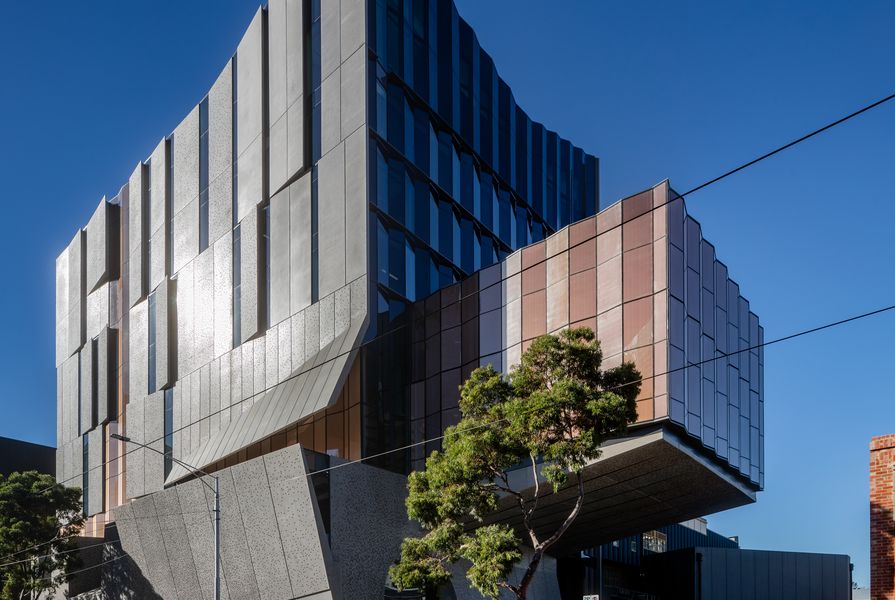 Concrete panels on the facade recede, tilt and fold to provide solar protection yet also reveal sliced silhouettes of life within. A dramatically cantilevered volume accommodates a recital hall.