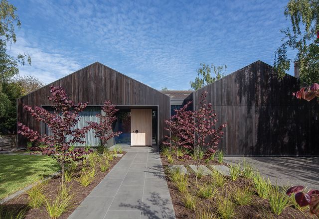 A striking facade of charcoal-stained timber radically alters the house’s appearance in the streetscape.