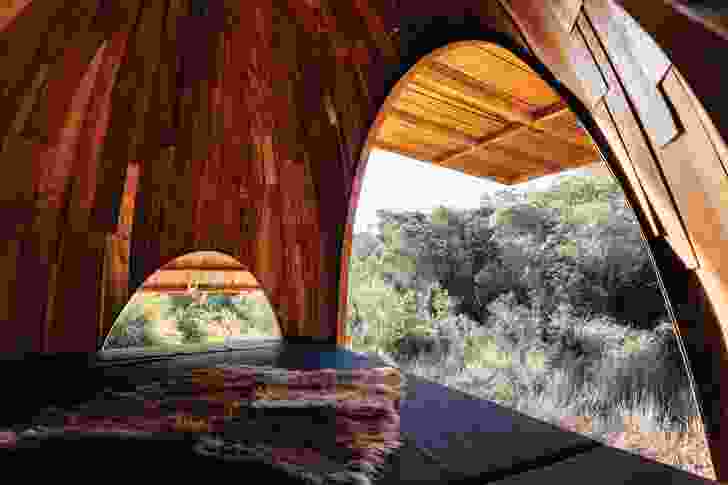 Arranged around the central eating and bathing pavilion are six dual-person sleeping huts that open to the landscape. Their inner domed volumes conceal pulley mechanisms.
