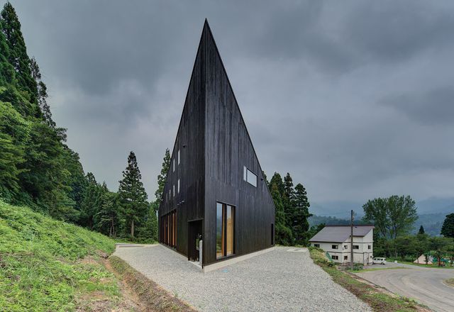 The dark, striking roof form serves a snow-shedding function.