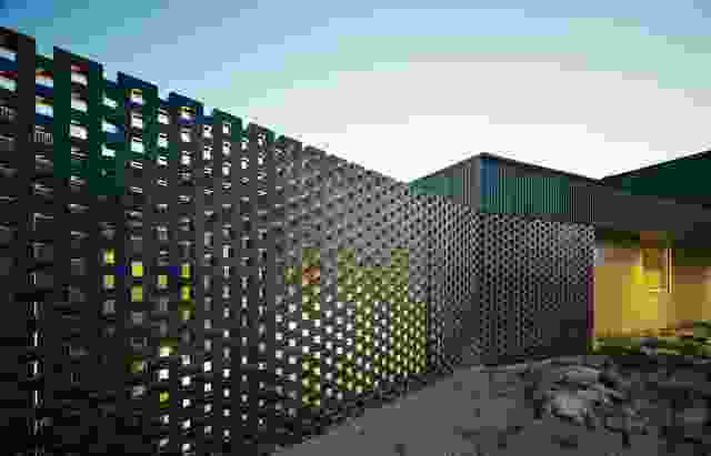 A perforated brick screen shields the northern courtyard from the street.