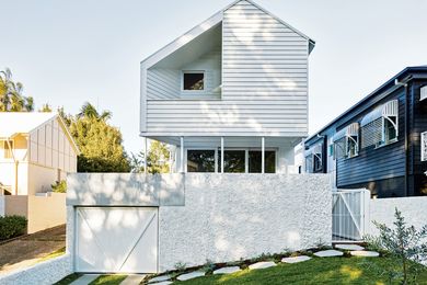 Set above a solid front wall, the upper level of the house steps away from the boundaries of its narrow site.