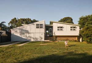 The existing home, now raised on a brick plinth, is paired with a new spine and connected with a glazed link.