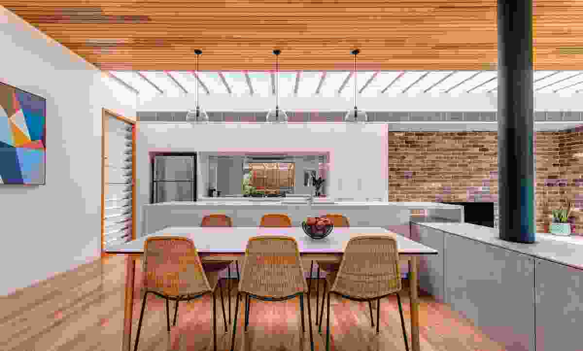 Rows of lush plant-filled terracotta pots in the courtyard are reflected in the kitchen’s splashback.