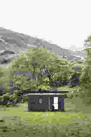 Slate Cabin, a writer’s retreat in Wales, is a reductive black box anchored to the ground, providing protection and respite to visitors.
