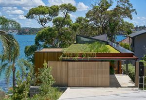 The roof’s garden overspills green tendrils on one side, and has an integrated strip of photovoltaic panels on the other.