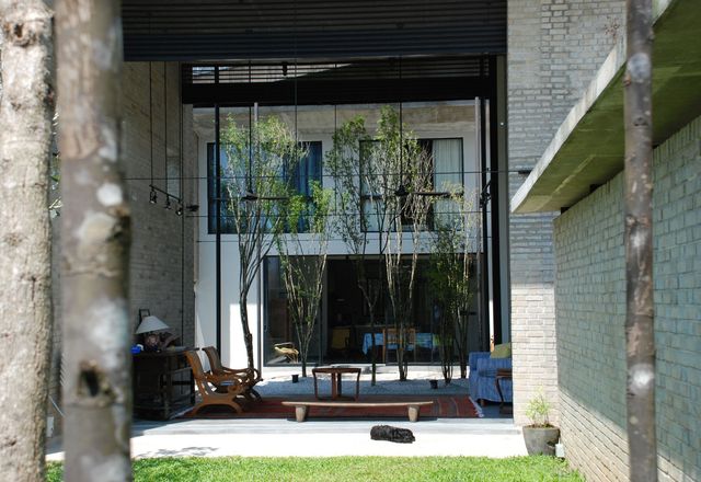 花园壳住宅-客厅的外壳有助于屏蔽从高架轨道到后方，同时使客厅在前花园和中间庭院之间的亭子