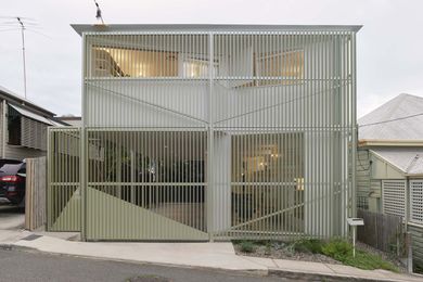 The house adopts the form and scale of neighbouring homes, but is set apart by details such as the aluminium screen.
