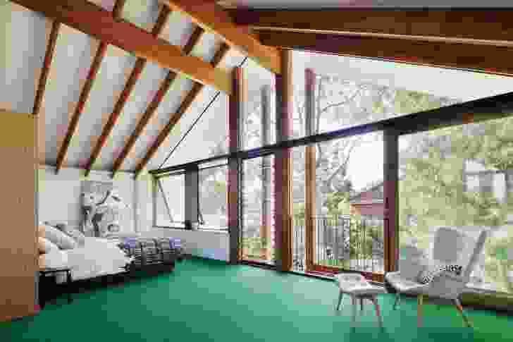 The light and airy bedroom suite on the first floor sits among the treetops, with the carefully detailed carpentry of the pitched roof exposed. Artwork: Helen Johnson.