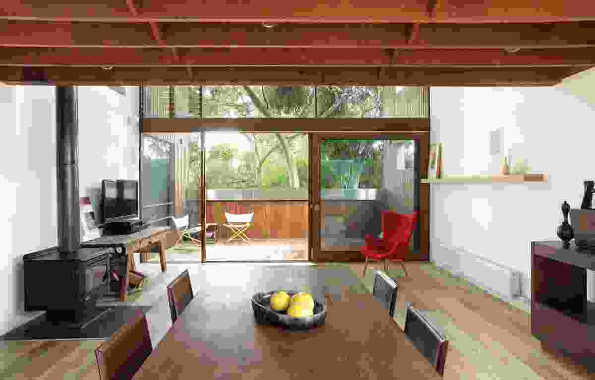 The lowered ceiling height over the dining area emphasizes the double-height volume of the living area and outdoor room.