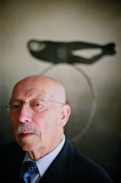 Enrico Taglietti, 2007 RAIA Gold Medallist. The background image shows a work by sculptor Rod Dudley. Part of a poster from the Bonythorn Gallery, 1973. Photograph Vikky Wilkes.