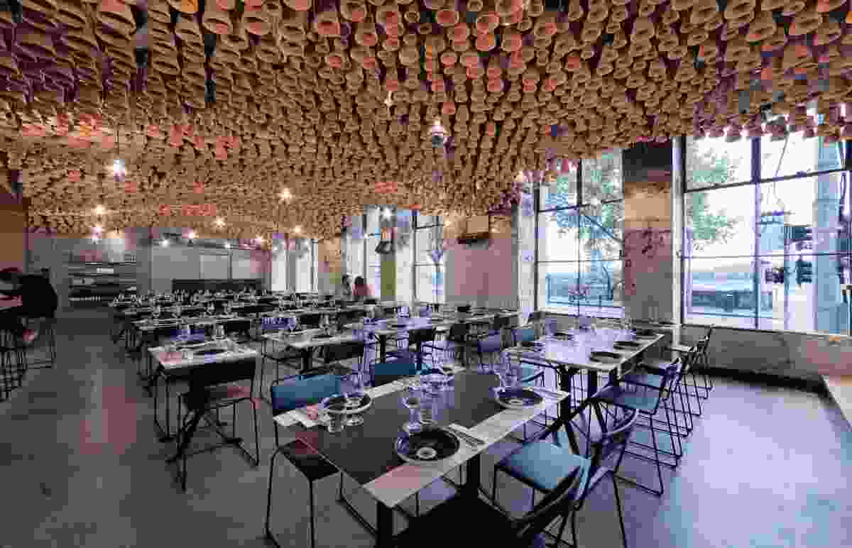 A beguiling ceiling installation made from terracotta pots hangs inside the fitout for Gazi in Melbourne.