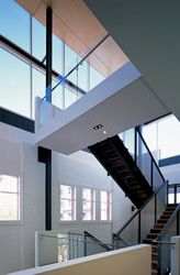 The foyer with
the new centrepiece stair. The massive steel frame
supporting the roof canopy is strutted to the warehouse
wall beyond. 