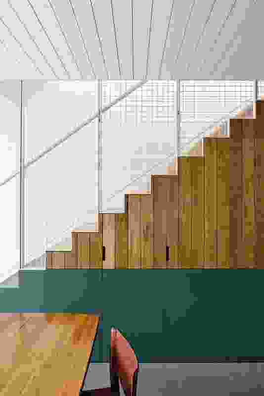 Joinery is concealed beneath the stair, maximizing space and utility on a compact site.