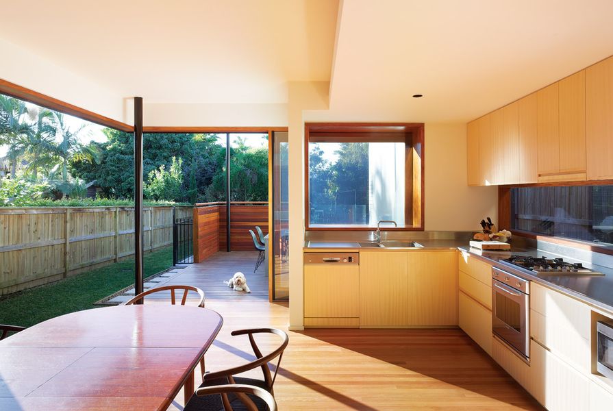 The glazed walls of the kitchen peel away to form a carved-out shell of wall and roof.