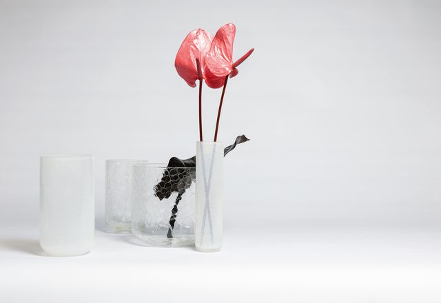 “裂纹花瓶”系列是由一排透明的、乳白色的玻璃容器组成，看起来就像是破碎了一样。