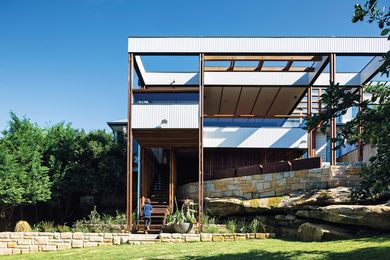 Propped above a dramatic sandstone rock shelf, the living spaces flow out to a new timber deck.