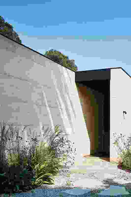 A crisp capping plate on the rammed earth walls controls water ingress and defines the lines of the building.