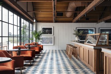 A Tasmanian blackwood island bar stands out against the checkered Italian tumbled marble tiled flooring.